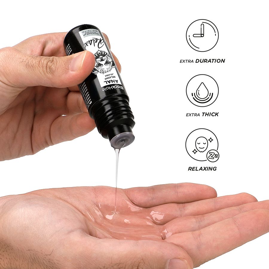Eine Hand hält eine schwarze Flasche, aus der eine klare Flüssigkeit in die Handfläche getropft wird. Icons zeigen "Extra Duration", "Extra Thick", "Relaxing".