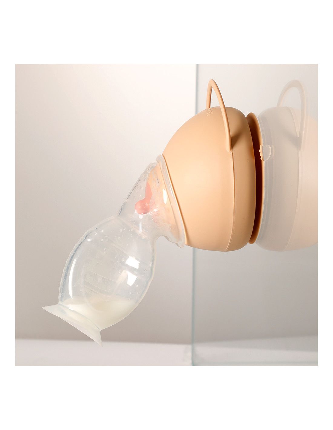 Elfenbeinfarbenes Brustmodell mit Milchbehälter. Milch fließt in einen transparenten Behälter.
