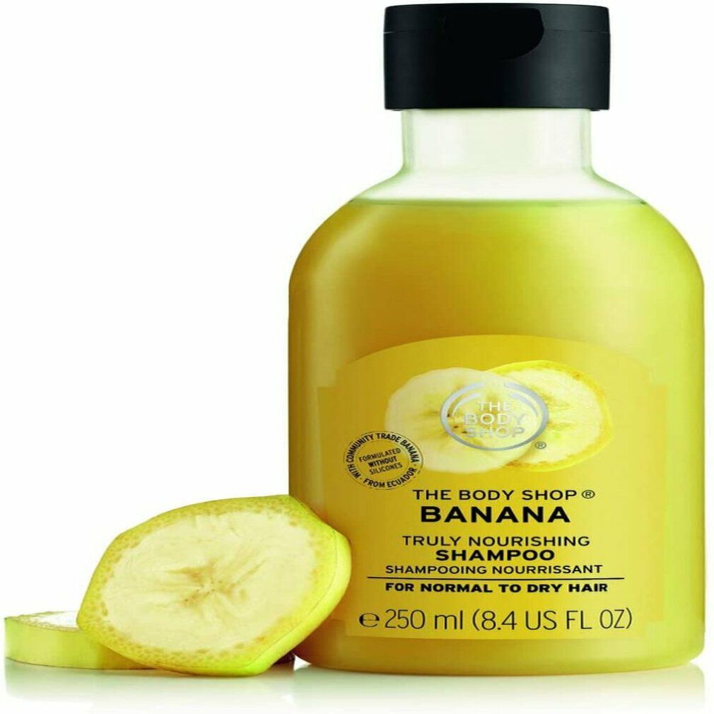 Gelbliche Shampoo-Flasche mit schwarzem Deckel und Bananenscheiben. Aufschrift: The Body Shop Banana Shampoo, 250 ml.