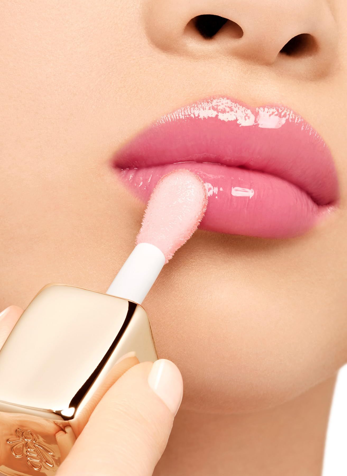 Lippen mit Applikator. Goldener Behälter mit Bienen-Logo. Anwendung.