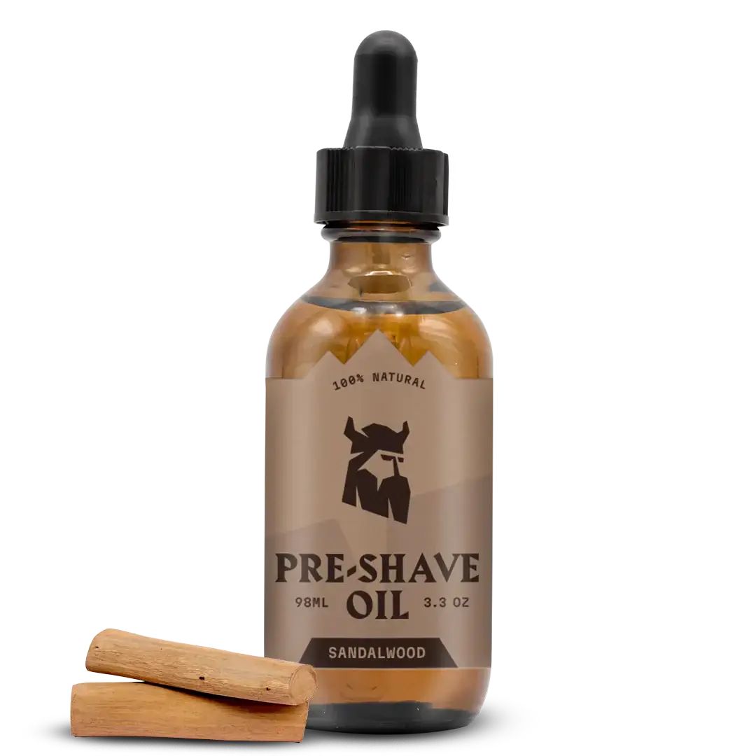 Braune Glasflasche mit schwarzem Tropfer. Aufschrift: Pre-Shave Oil, Sandelholz. Zwei Holzstücke liegen davor.