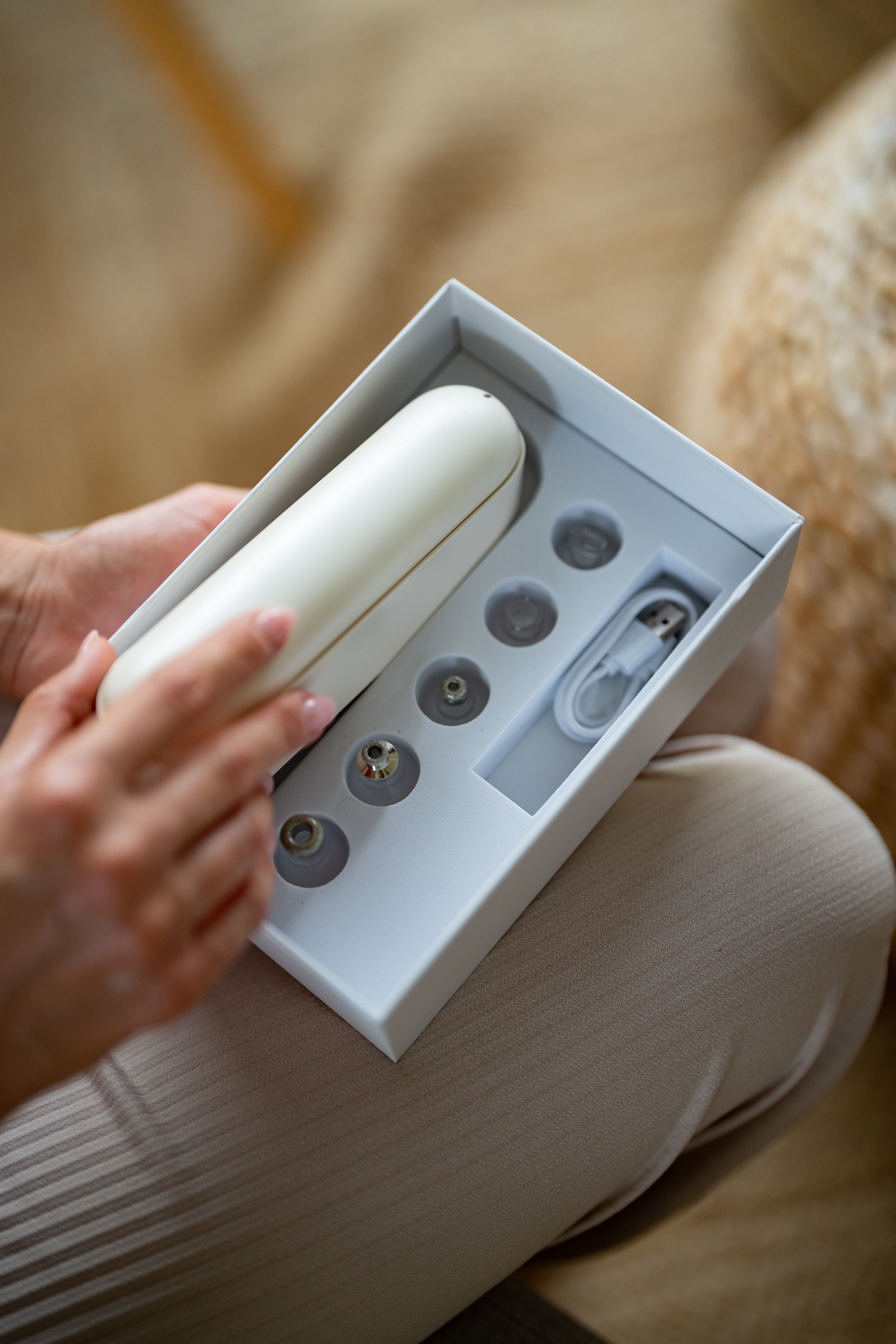 Hände halten eine weiße Box mit Zubehör für BEAUTIFLY B-Derma Glow Diamant Mikrodermabrasion.