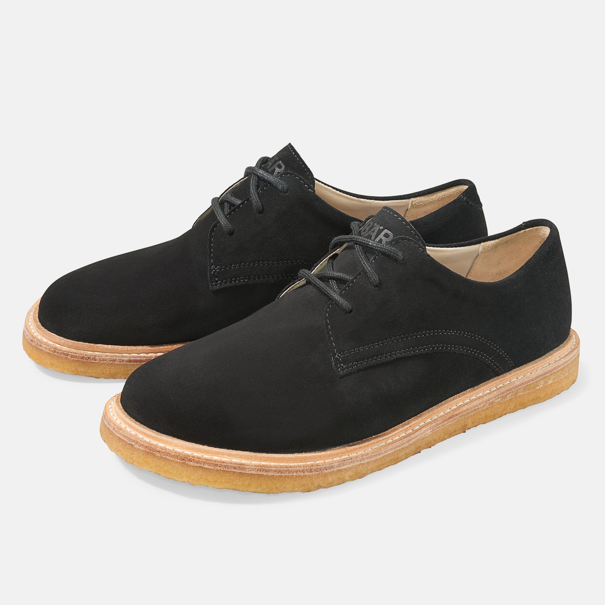 Paar schwarze Schnürschuhe mit heller Sohle. BÄR-Logo auf der Zunge. Breiter Schnitt.