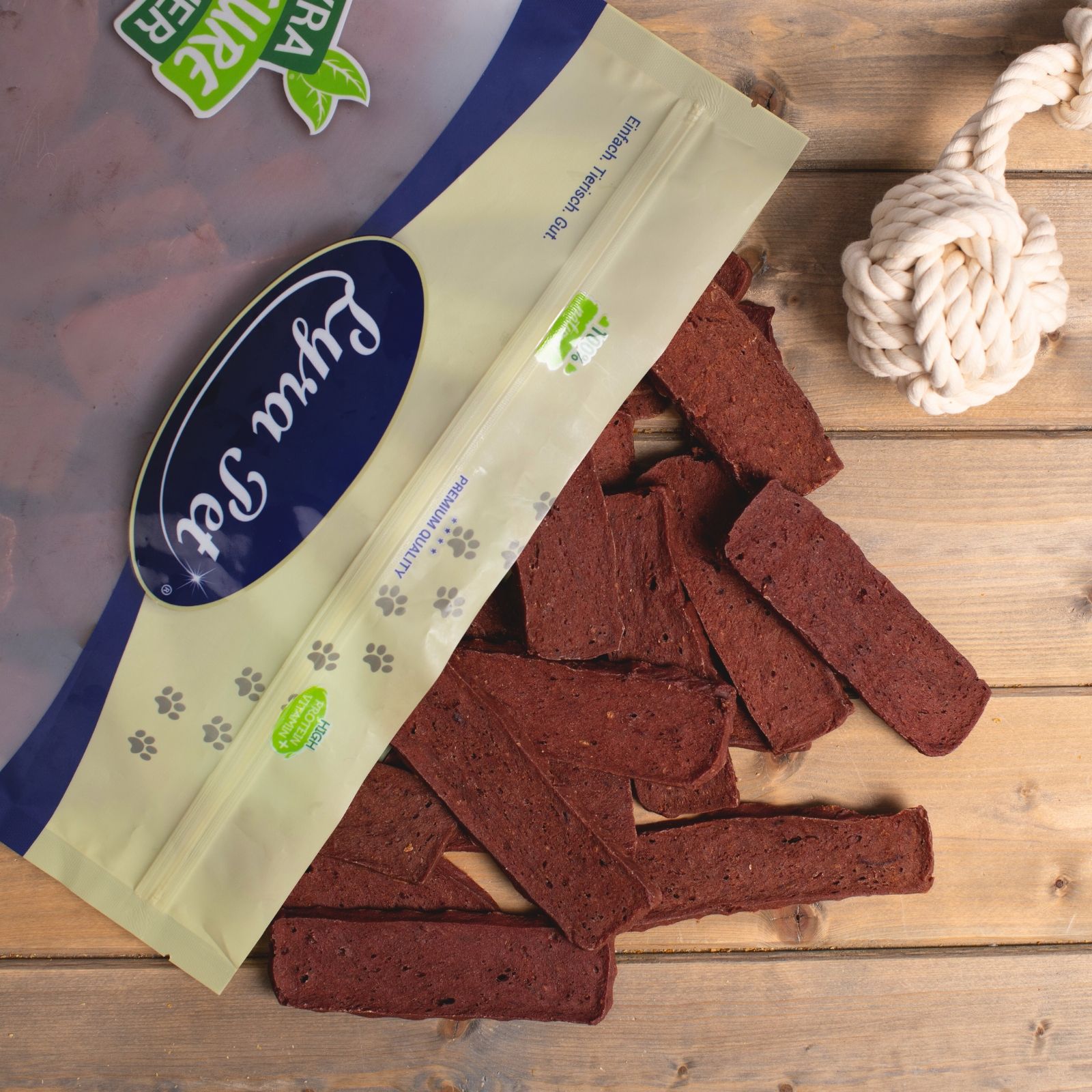 Lyra Pet Packung mit Hundeleckerlis und Hundebildern.