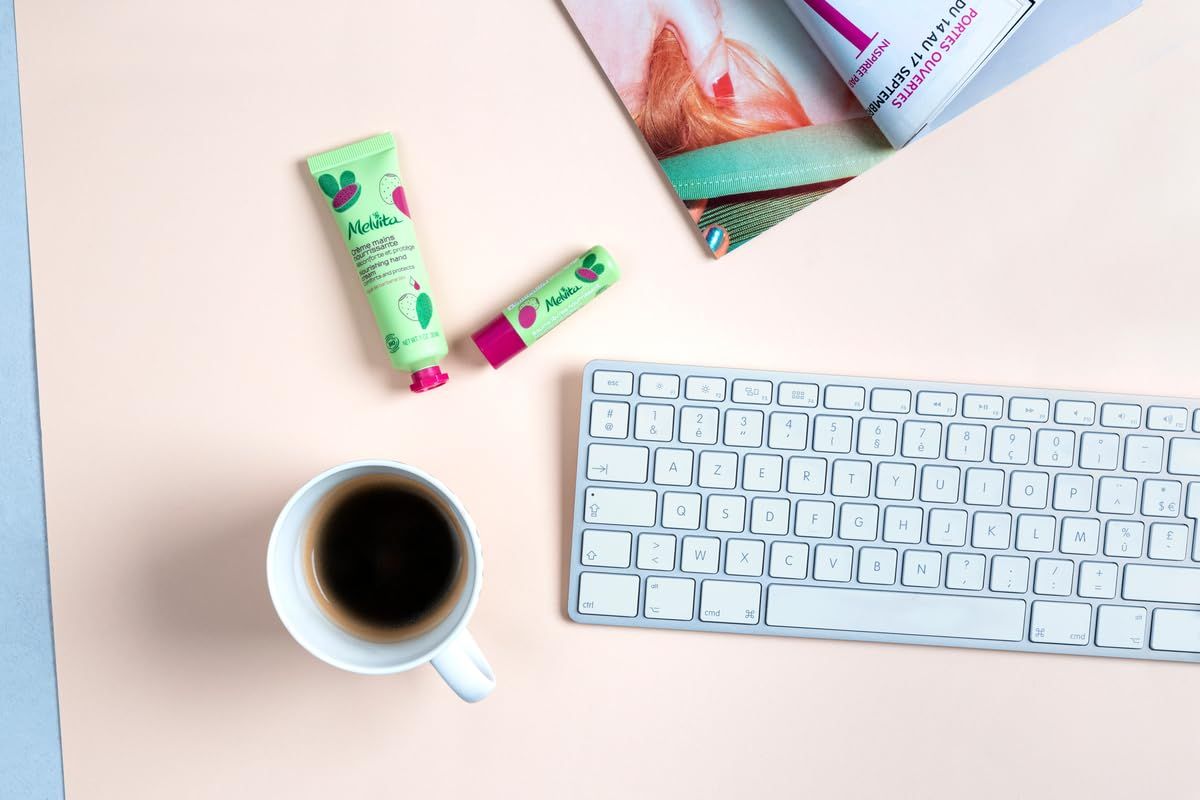 Arbeitsplatz mit Tastatur, Kaffee und M2 Beauté Kosmetikprodukten.