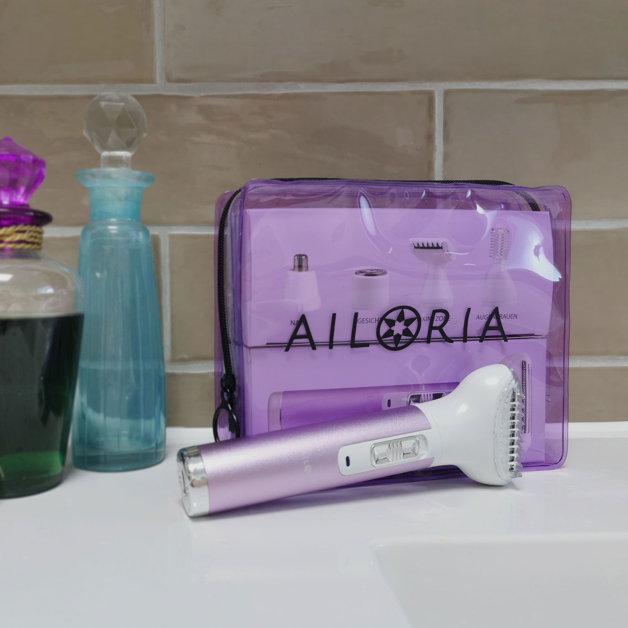 AILORIA EVAPORE Set in transparenter, lila Tasche. Rasierer und Aufsätze sichtbar. Auf einer Oberfläche.