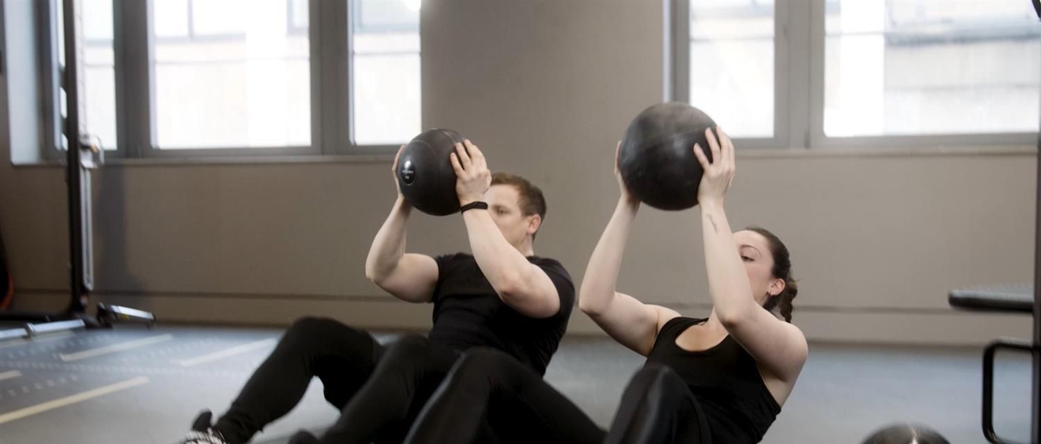 Zwei Personen heben jeweils einen schwarzen Slamball.