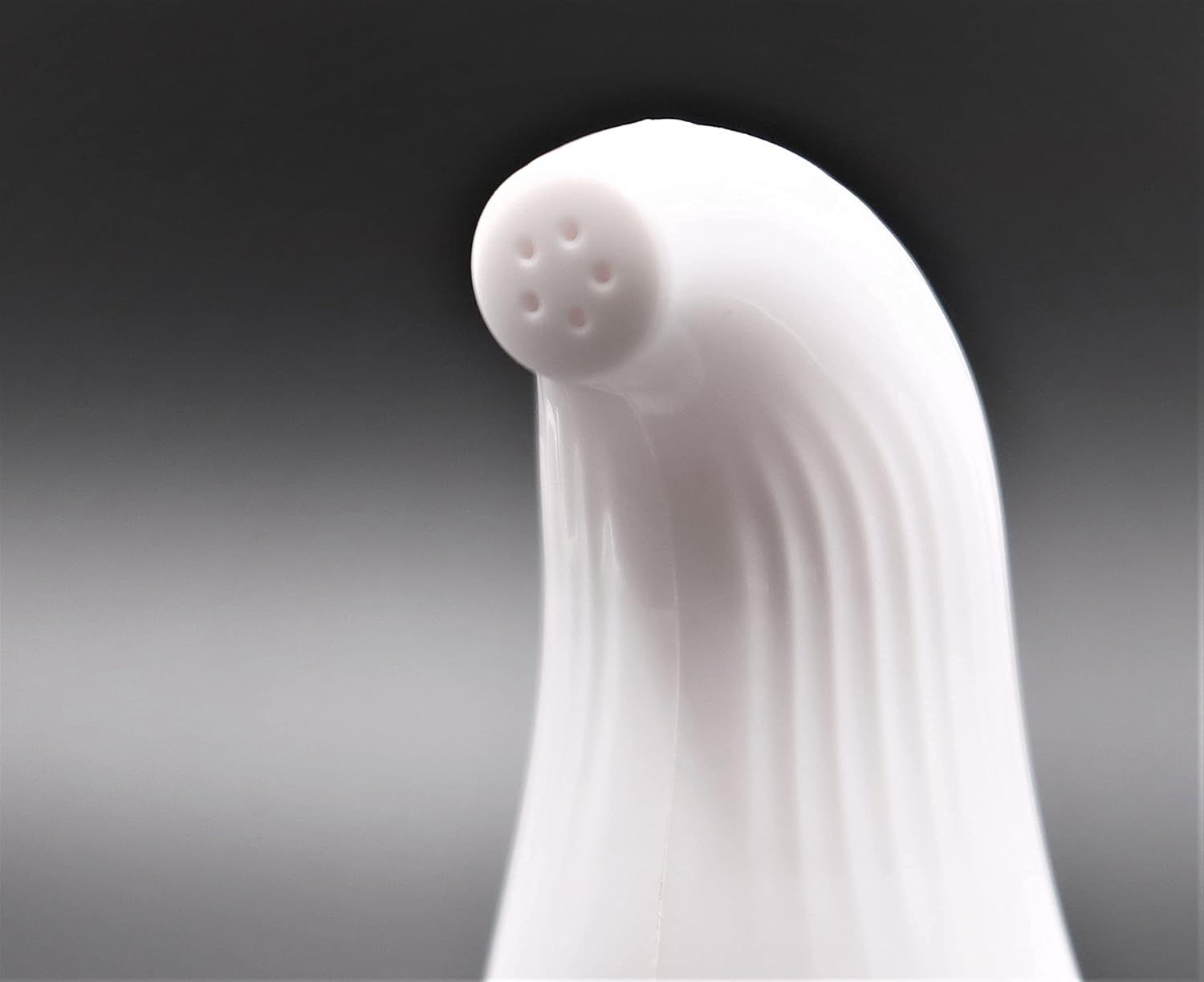 Nahaufnahme der Sprühspitze eines weißen Vaginaldusche-Aufsatzes mit vier kleinen Löchern.