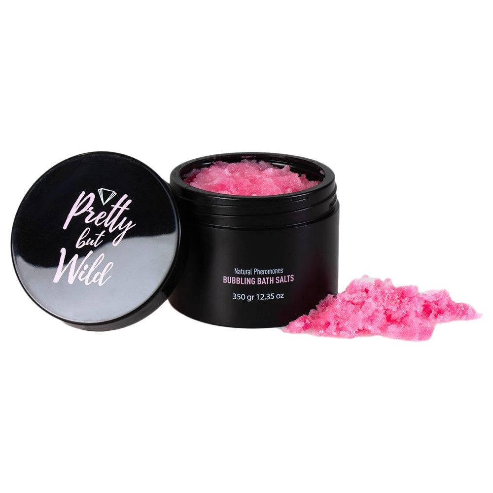 Schwarzer Tiegel mit rosa Badesalz und Deckel daneben. Aufschrift "Pretty but Wild".