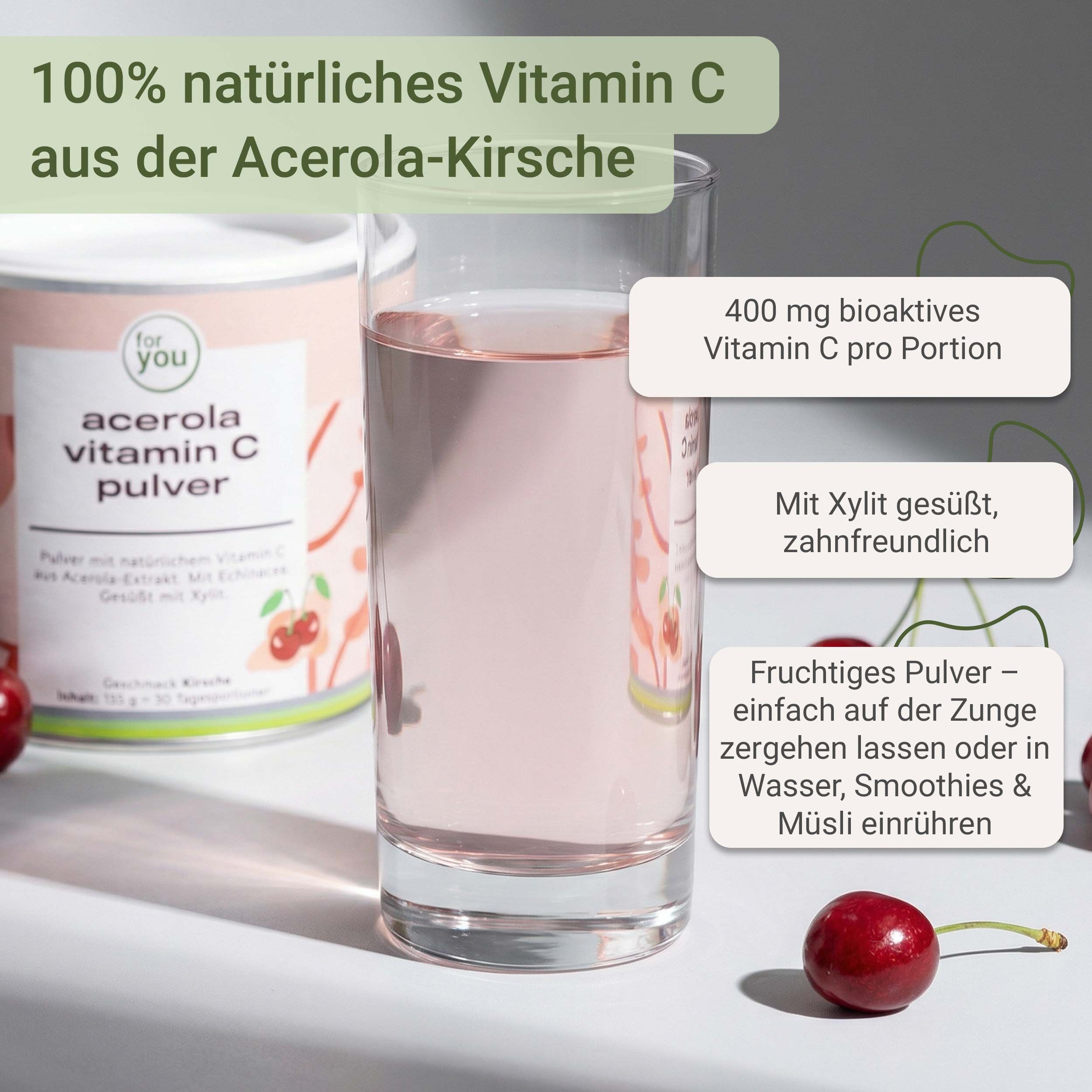 Glas mit rosa Flüssigkeit, daneben Dose mit Produktaufschrift. Kirschen liegen daneben. Text: 100% natürliches Vitamin C, 400 mg Vitamin C pro Portion.