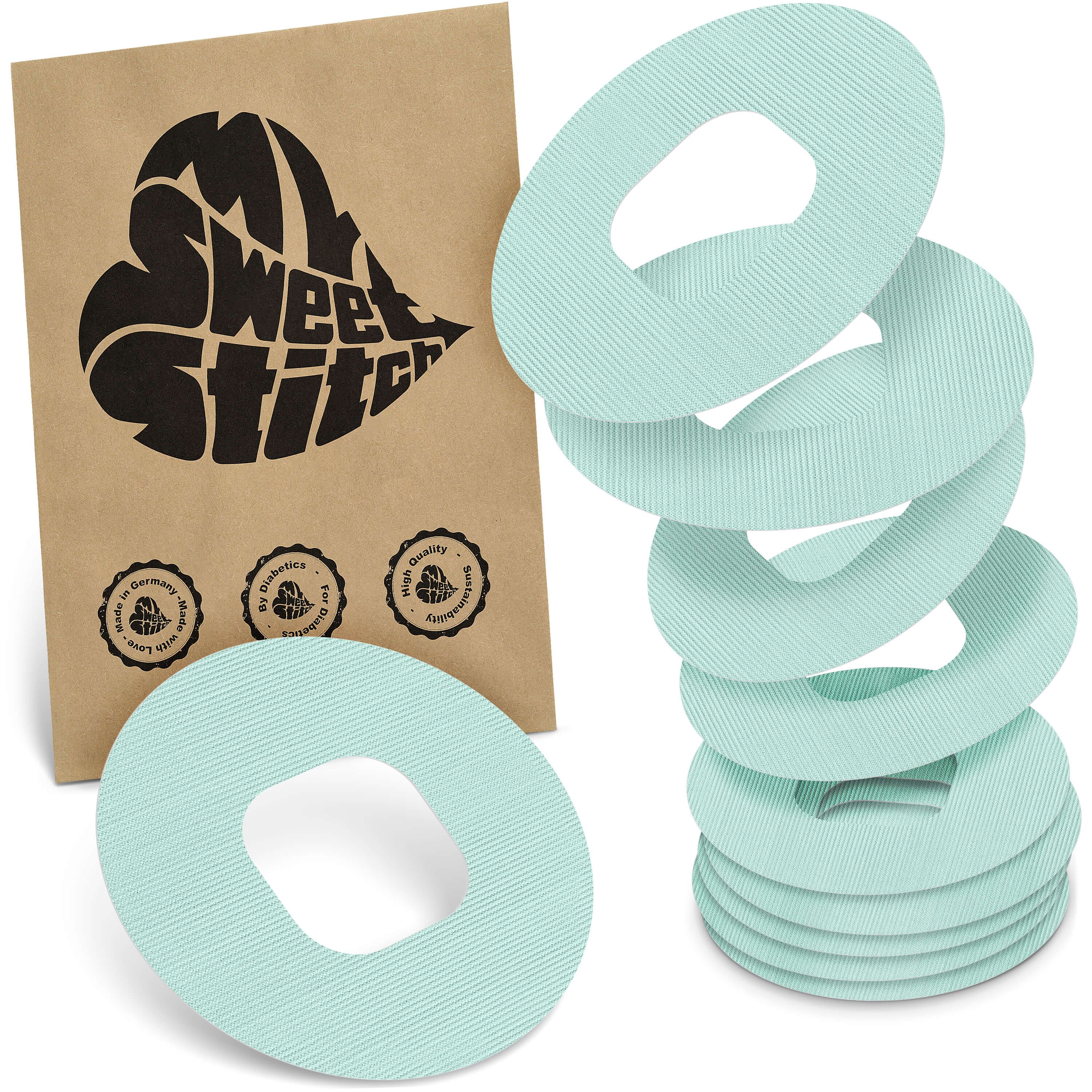 Mehrere runde, helltürkise Ringpflaster mit zentraler Öffnung. Auf brauner Verpackung steht "My Sweet Stitch".
