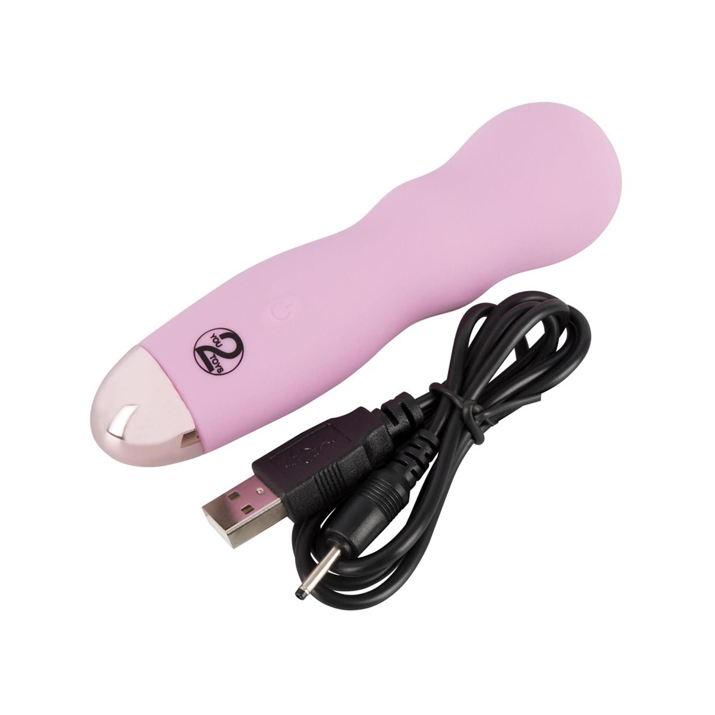 Rosa Mini-Vibrator mit USB-Ladekabel. Zylindrische Form, silberfarbene Spitze. Logo. Schwarzes Kabel.