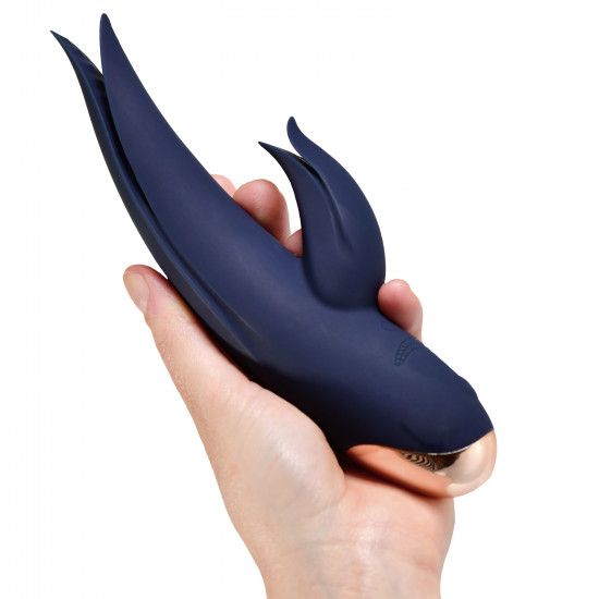 Dunkelblauer Vibrator in einer Hand gehalten. Goldfarbener Akzent an der Spitze. Zwei Flügel.