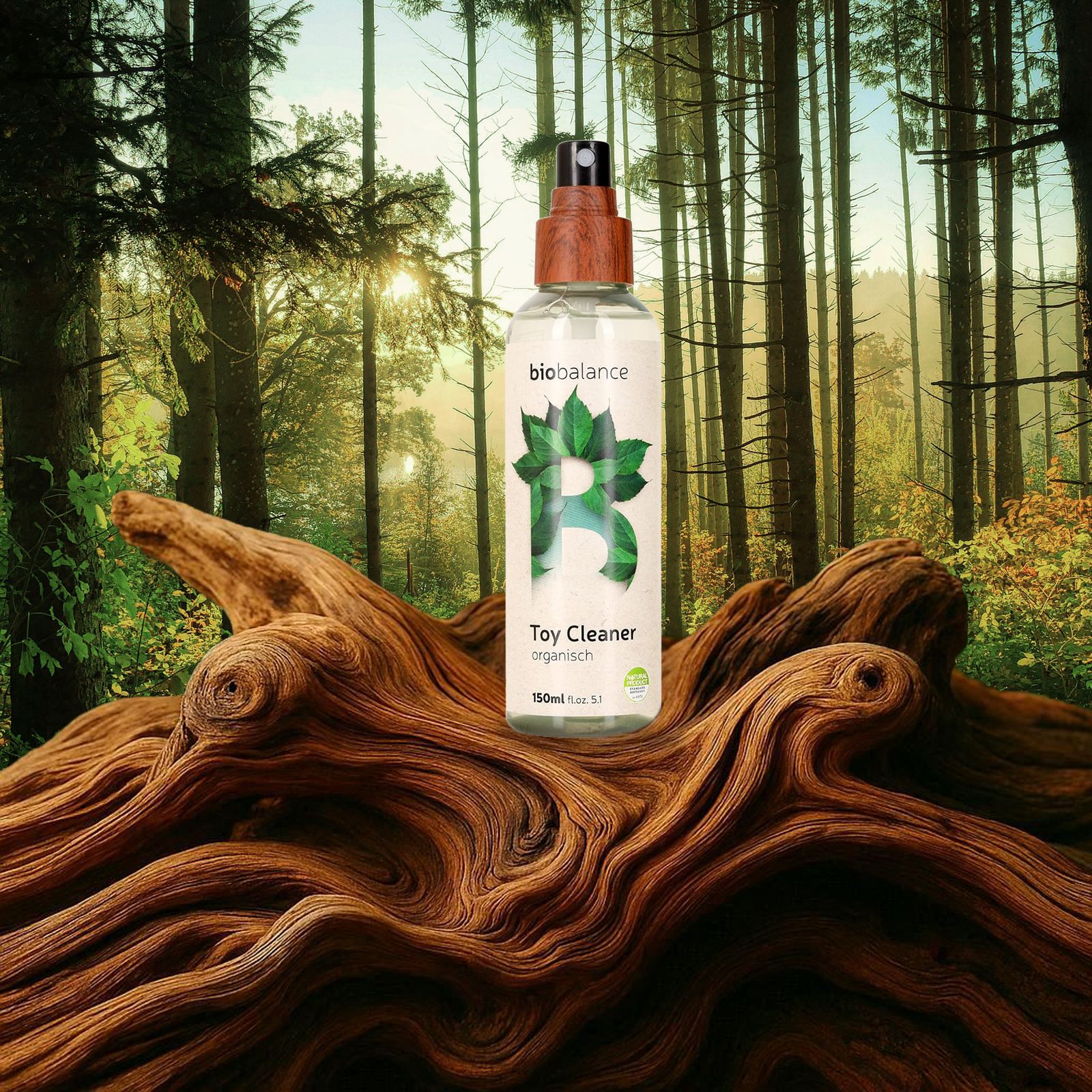 BIO BALANCE Toy Cleaner, organisch. Flasche mit Holz-Sprühkopf auf Baumstamm im Wald.