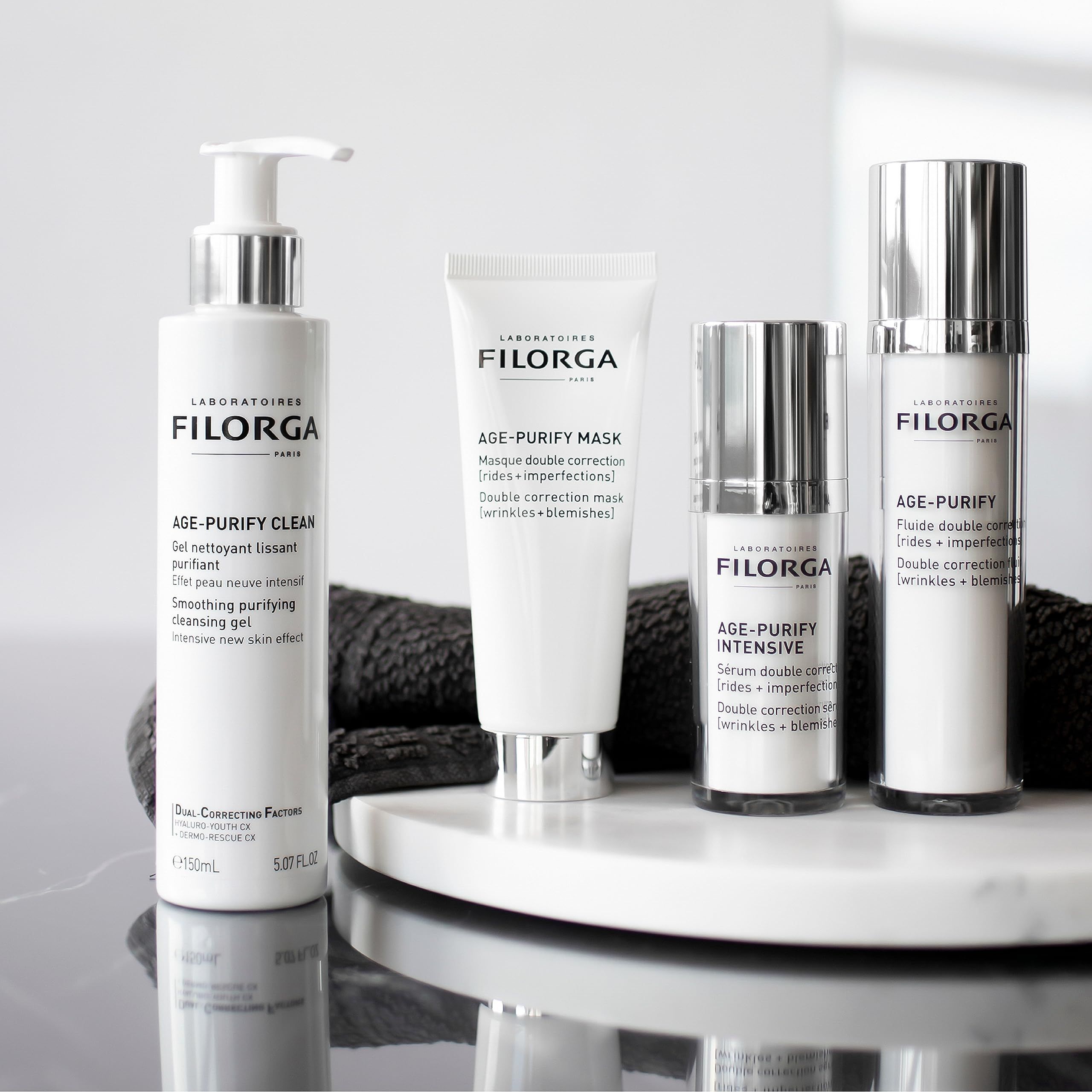 Produktreihe von Filorga. Enthält Age-Purify Serum, Maske und Reiniger. Schwarzer Hintergrund.