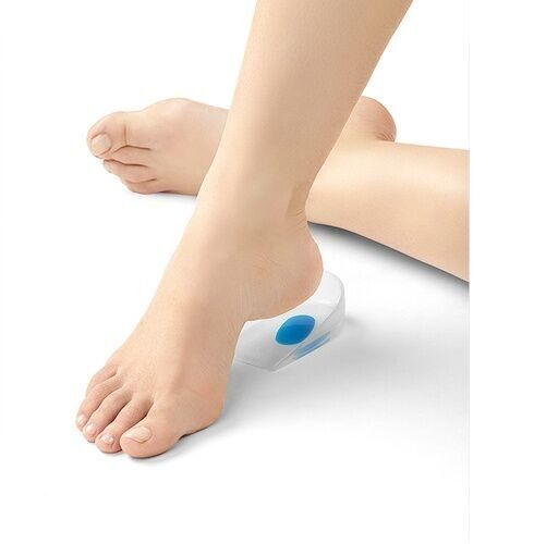 Fuß auf einem transparenten Fersenkissen mit blauem Einsatz. Der Fuß ist leicht angehoben.