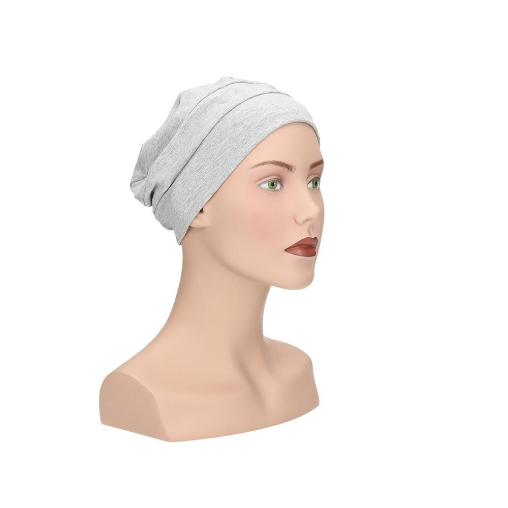 Hellgrauer Turban auf einer Schaufensterpuppe. Schräge Ansicht. Stoffhaube mit breitem Saum.