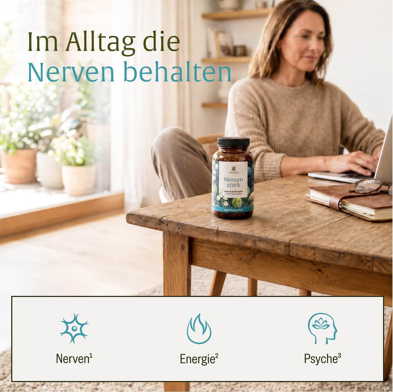 Flasche Naturtreu Nerven stark Vitamin B-Komplex auf einem Holztisch, mit Frau im Hintergrund, die auf einem Laptop arbeitet.