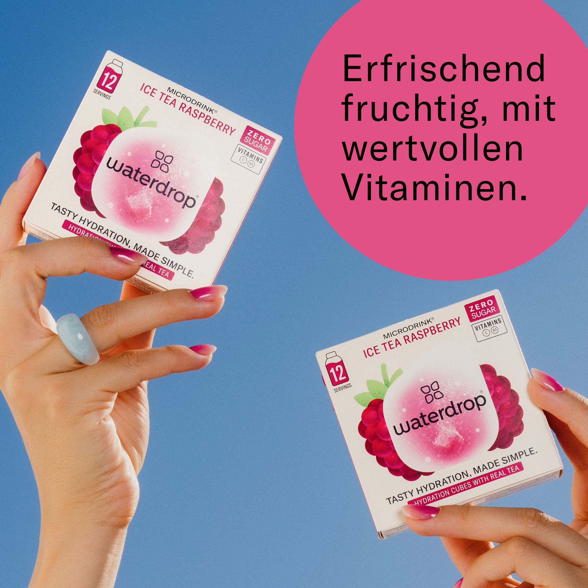 Hände halten zwei waterdrop®-Boxen. Text: Erfrischend fruchtig, mit wertvollen Vitaminen. Logo und Text: Ice Tea Raspberry, Zero Sugar.