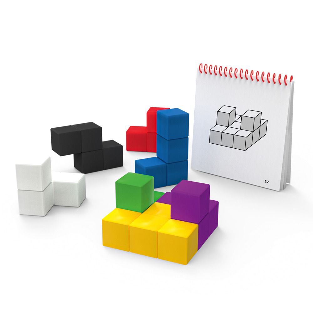 Geowürfel-Set mit farbigen Würfeln und einem Notizbuch mit Zeichnungen. Würfel in verschiedenen Farben liegen auf einer weißen Oberfläche.