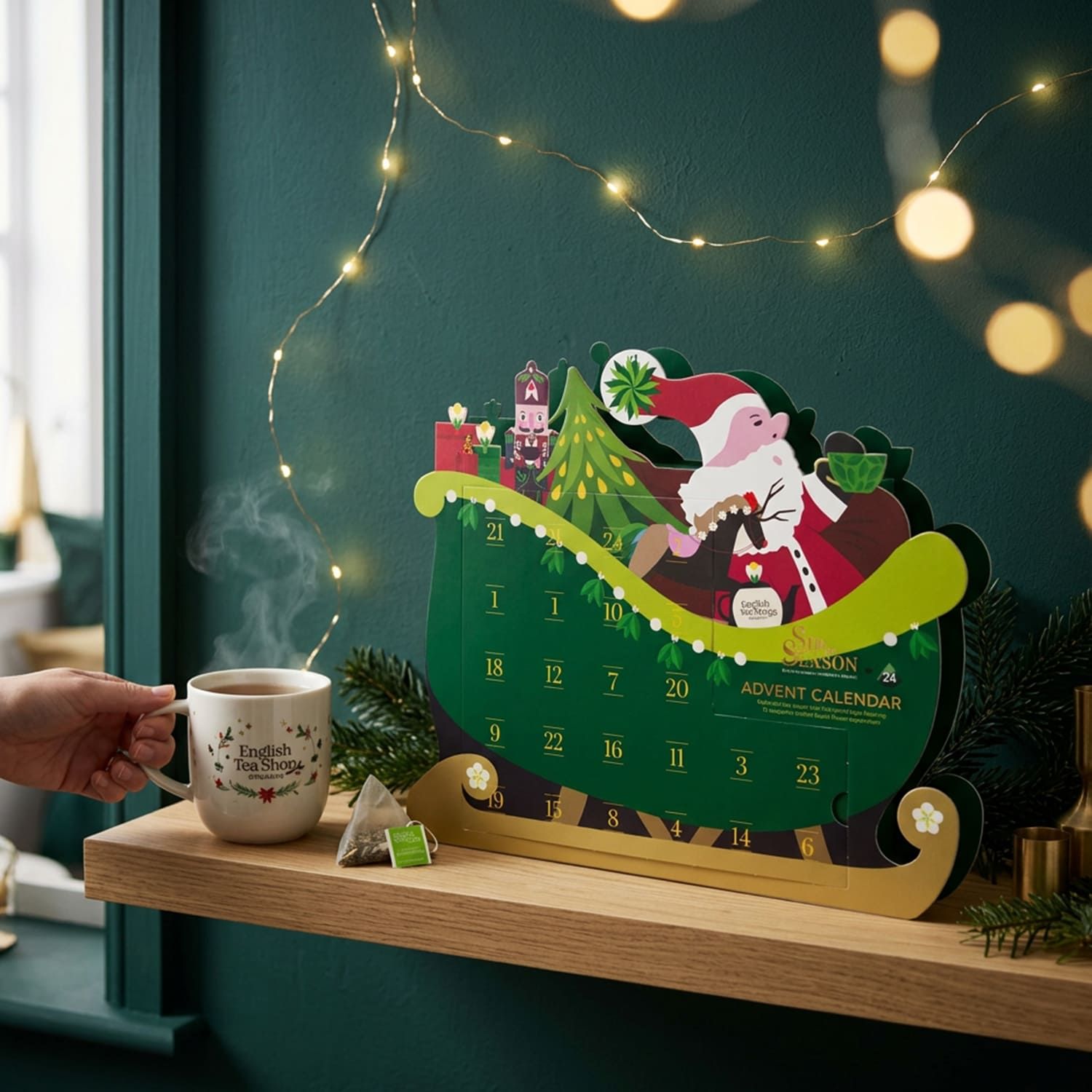 Adventskalender auf Regal mit dampfender Tasse Tee. Kalender in Schlittenform, mit Nikolaus-Motiv.