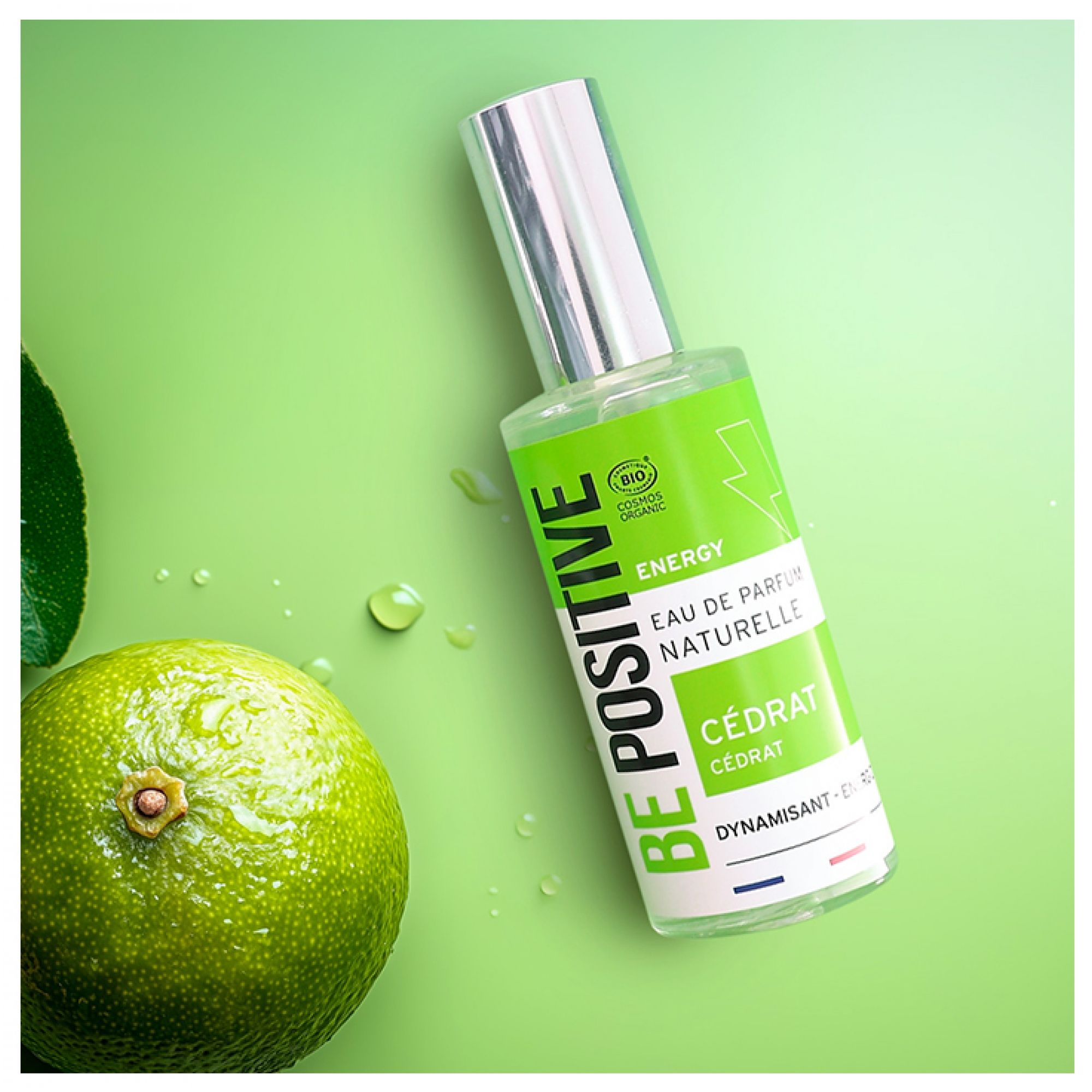 Acorelle Be Positive Eau de Parfum Energy Cedrat Flakon neben einer Limette auf grünem Hintergrund mit Wassertropfen.