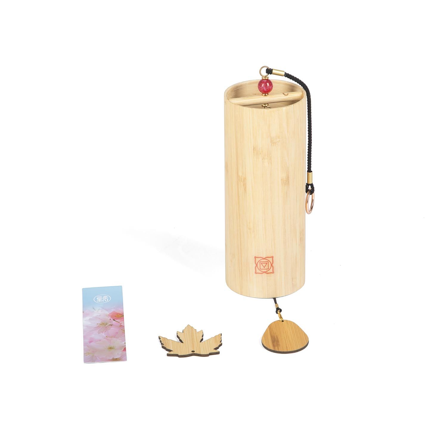 Klangspiel aus Bambus mit Holzblatt und Karte. Zylindrische Form, rotes Chakra-Symbol. Hängevorrichtung mit roter Kugel.
