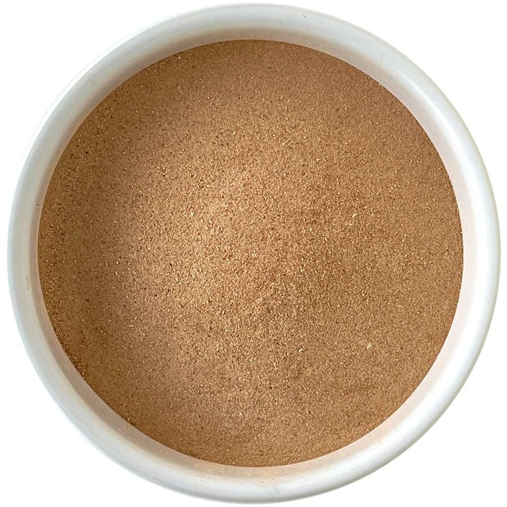 Nahaufnahme einer weißen Schale mit braunem Pulver. Der Inhalt ist fein gemahlen und füllt die Schale.