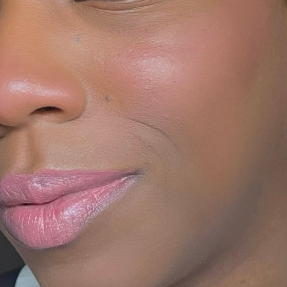 Nahaufnahme von Gesicht mit rosa Lippen und Wangen. Hautton. Oberer Teil des Gesichts sichtbar.