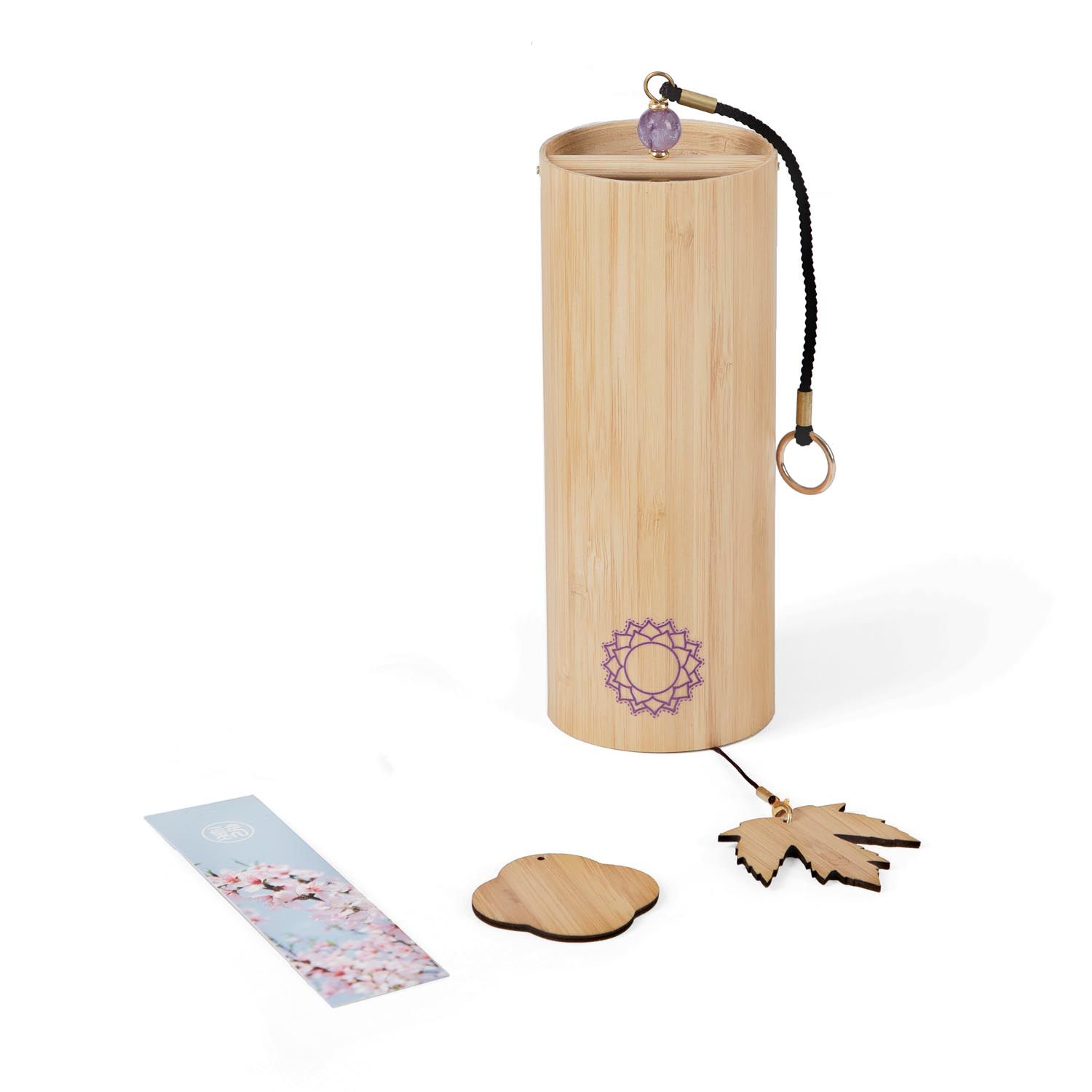 Klangspiel aus Bambus. Lila Chakra-Symbol. Holzblatt und -wolke. Karte mit floralem Muster. Amethyst-Kugel. Schwarze Schnur.