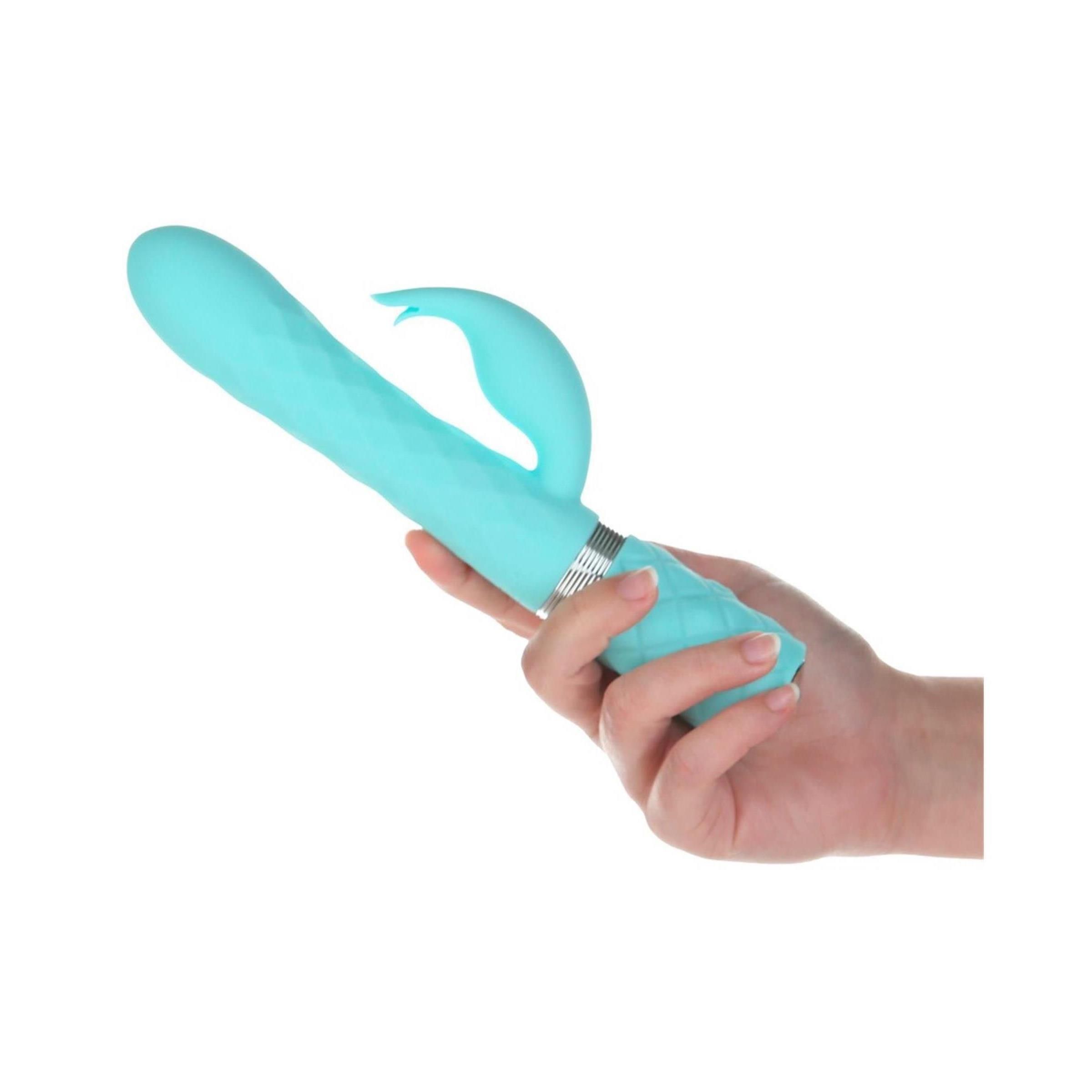 Hand hält blaugrünen Vibrator. Geriffelte Oberfläche, gebogene Spitze. Silberner Ring. Auf weißem Hintergrund.