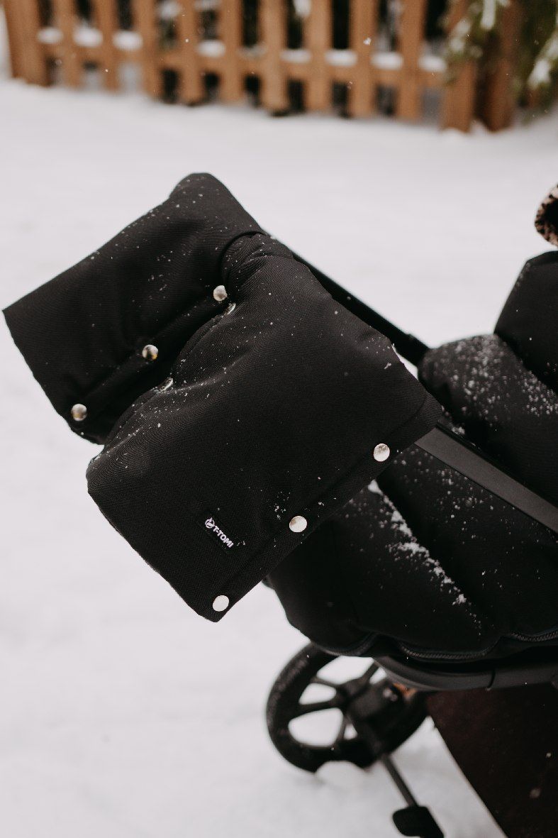 Schwarze, gepolsterte Kinderwagen-Fäustlinge mit Druckknöpfen und einem kleinen Logo.
