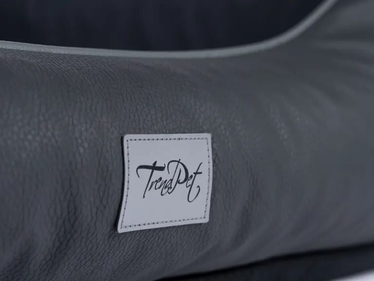 Nahaufnahme des grauen Kunstleders. Weißes Etikett mit dem Schriftzug TrendPet.