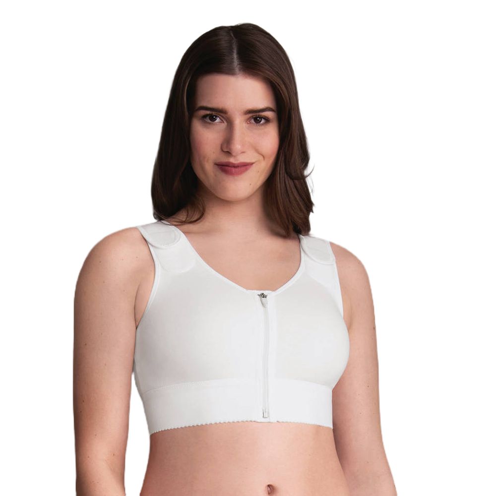 Weißes Kompressionsbandage mit Vorderverschluss. Reißverschluss mittig, breite Träger, gepolsterte Schultern. Frau trägt das Produkt.