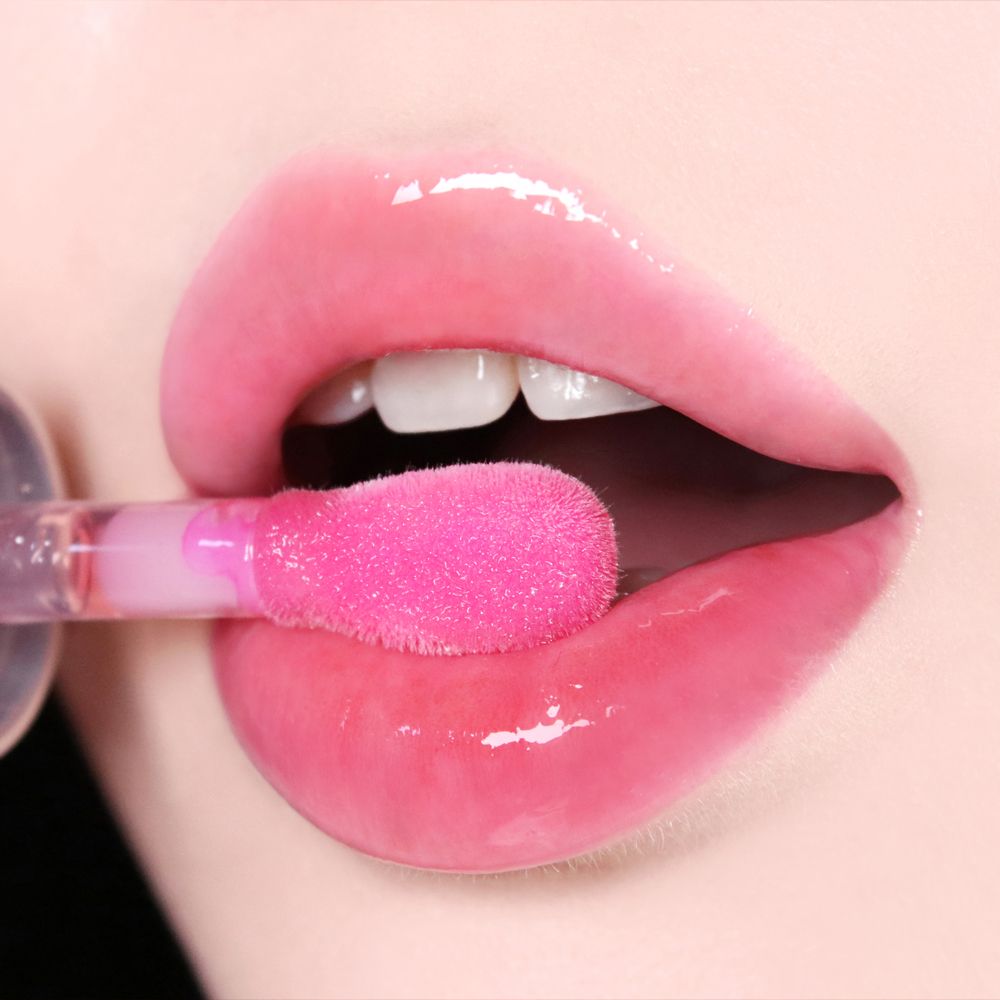Nahaufnahme von Lippen, die mit Lip Oil benetzt werden. Applikator mit rosa Spitze.