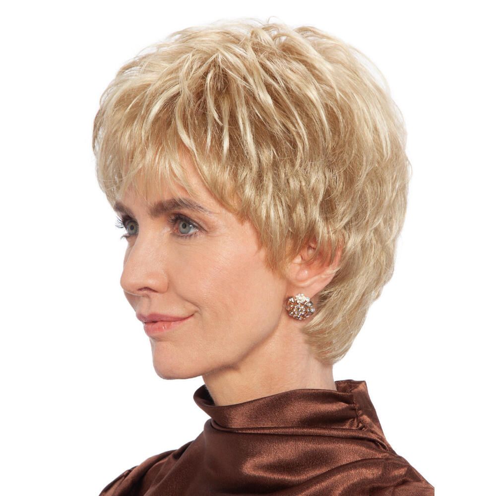 Blond gefärbte Perücke. Kurzer, gestufter Schnitt. Frau mit brauner Bluse. Seitenansicht.