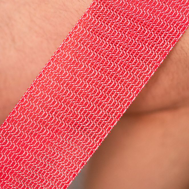 Nahaufnahme eines roten Stoff-Fitnessbands. Gewebestruktur sichtbar.