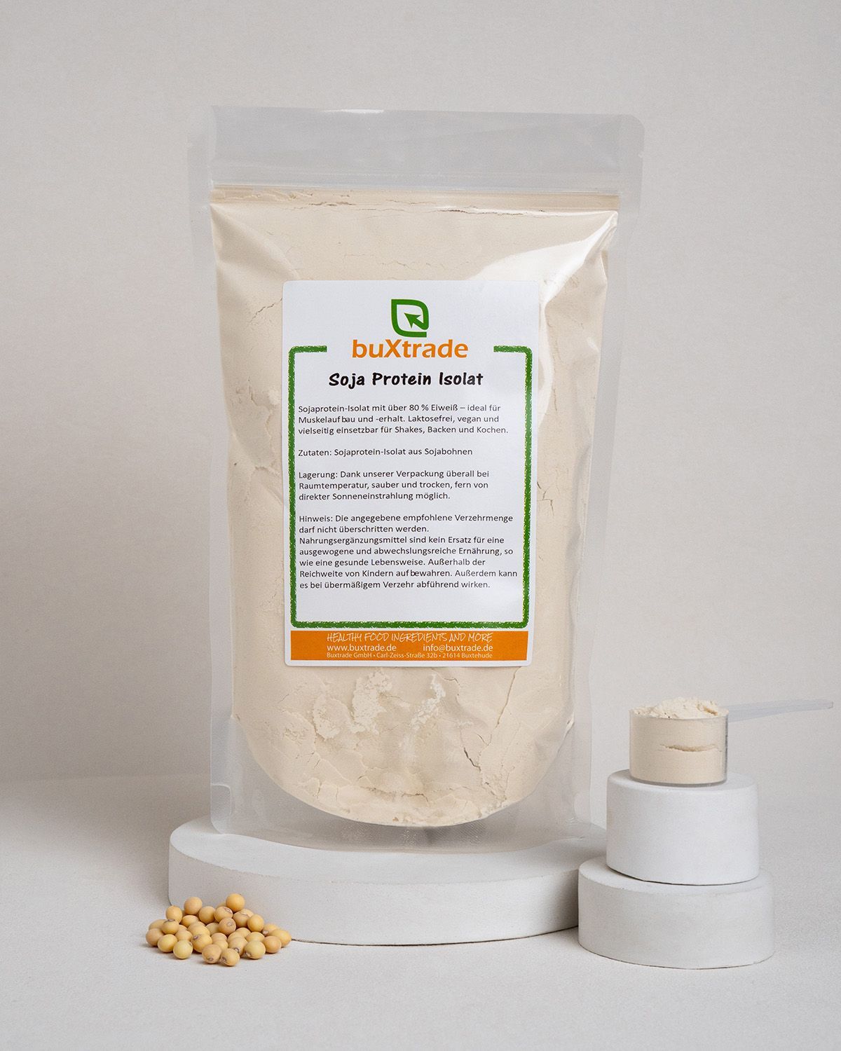 Transparente Verpackung mit beigem Pulver, Messlöffel und Sojabohnen. Aufkleber mit Produktinformationen: buXtrade Soja Protein Isolat.