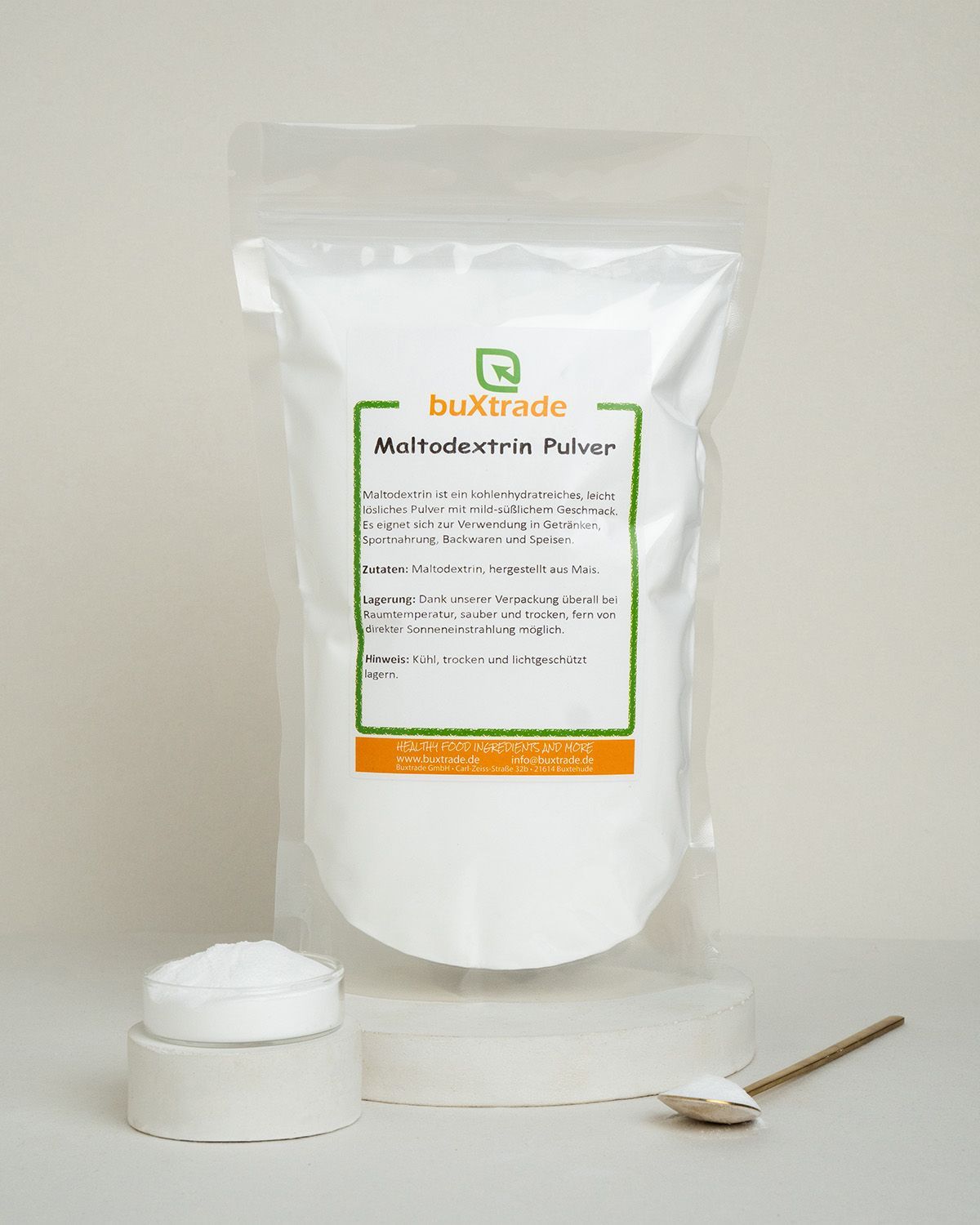 Buxtrade Maltodextrin Pulver in weißem Standbeutel, daneben ein Glas mit Pulver und ein Löffel.
