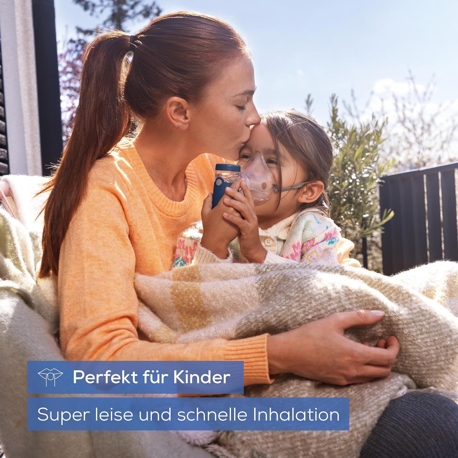 Mutter küsst Kind, das mit Inhalationsgerät inhaliert. Text: Perfekt für Kinder. Super leise und schnelle Inhalation.