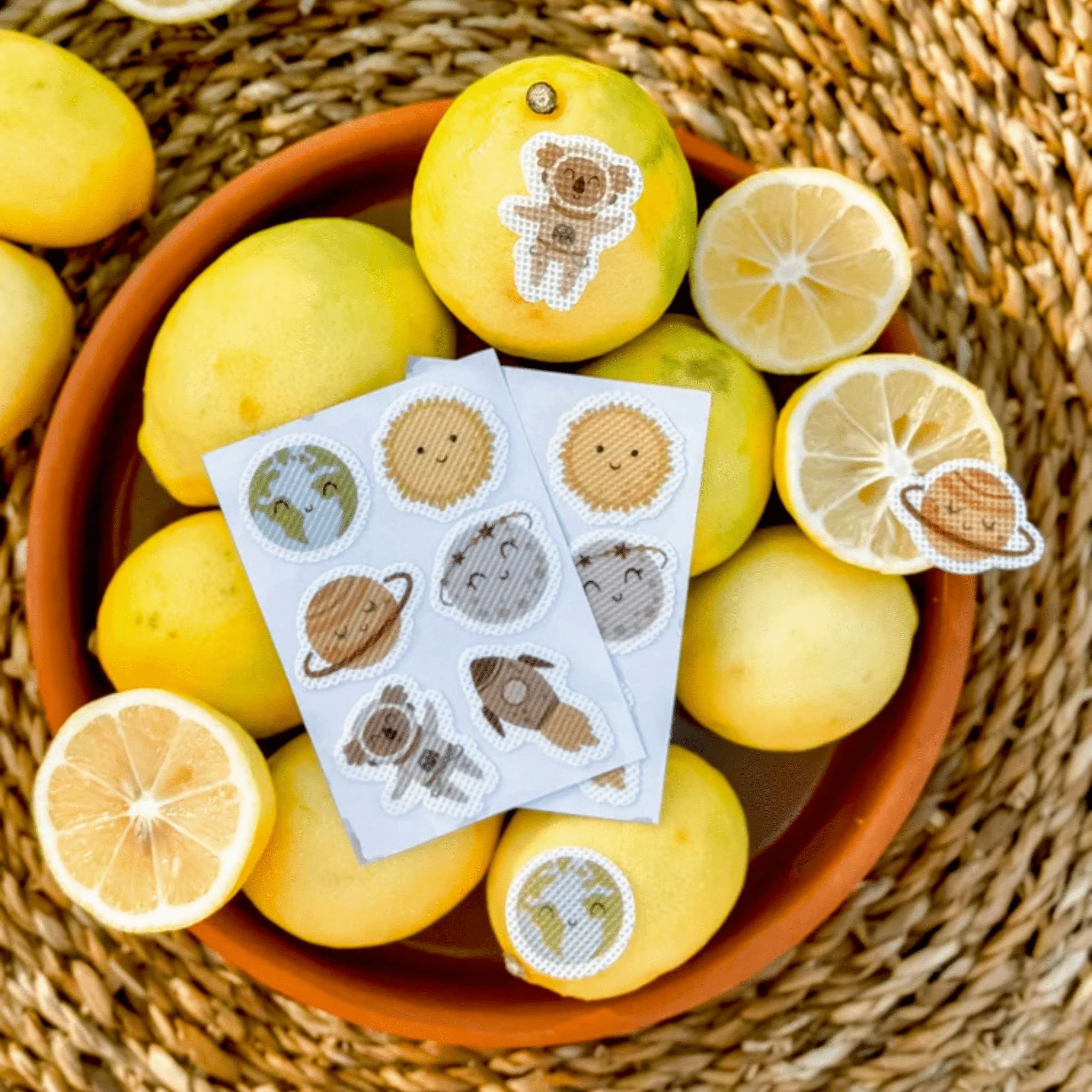 Anti-Mücken-Sticker im Weltraum-Design auf Zitronenscheiben: Koala, Rakete, Erde, Sonne, Planet.