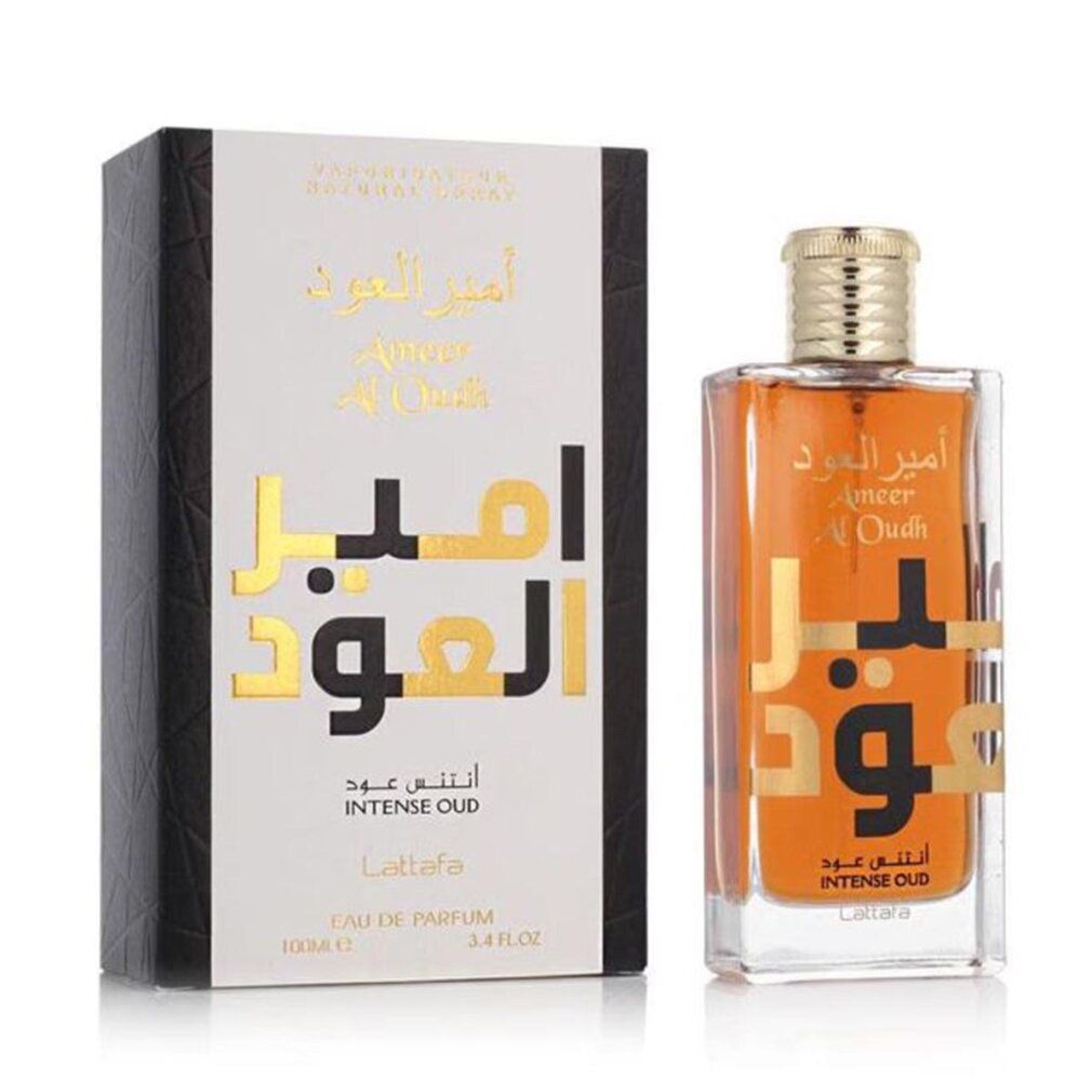 Parfümflasche und Verpackung. Flasche mit goldfarbenem Verschluss, brauner Flüssigkeit und goldfarbenem Schriftzug. Verpackung weiß mit schwarzem Rand.