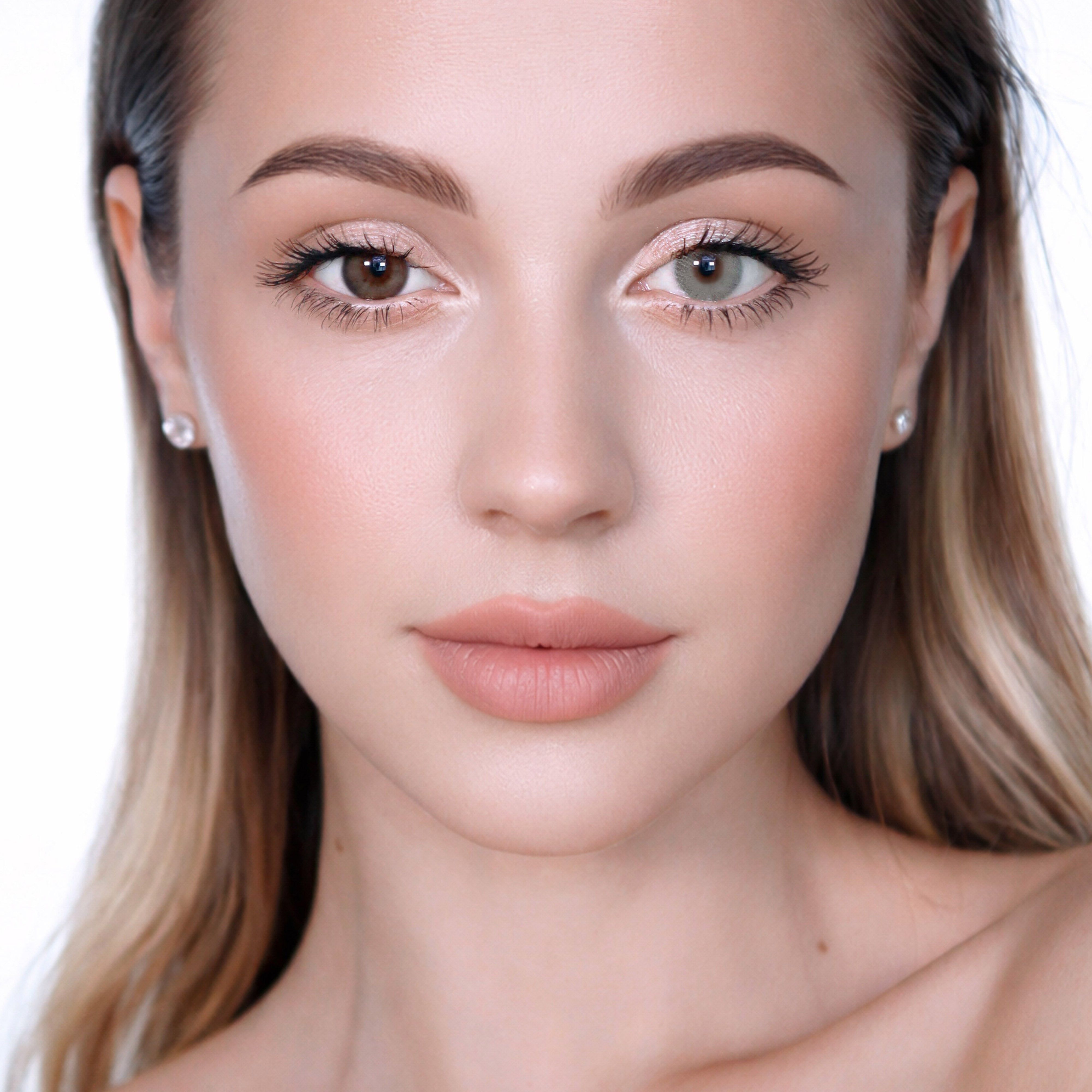 Nahaufnahme einer Frau mit unterschiedlich farbigen Augen. Ein Auge ist braun, das andere grün. Die Frau blickt direkt in die Kamera.