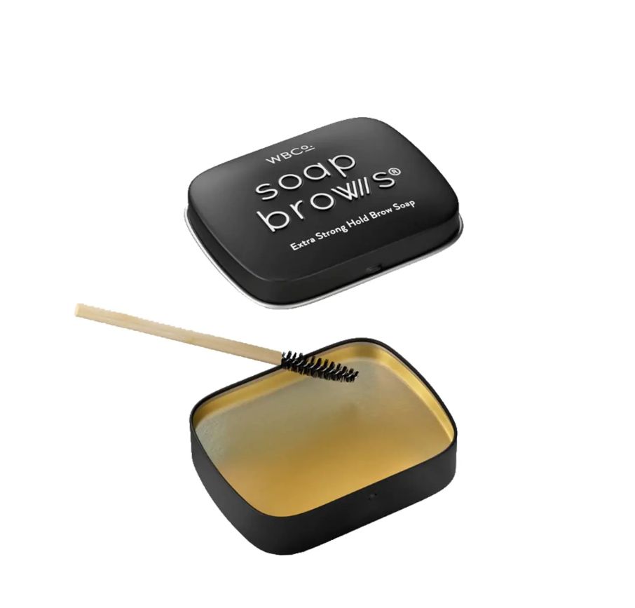 Geöffnete Soap Brows Dose mit Bürste. Dose schwarz mit goldener Innenseite. Bürste mit Holzgriff.