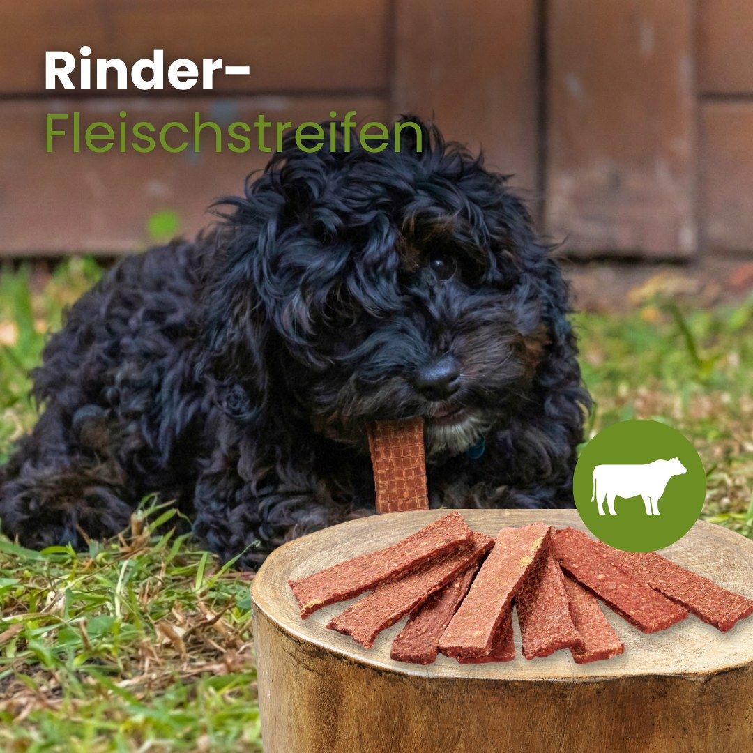 Rinder-Fleischstreifen für Hunde, auf einem Holzstamm präsentiert.