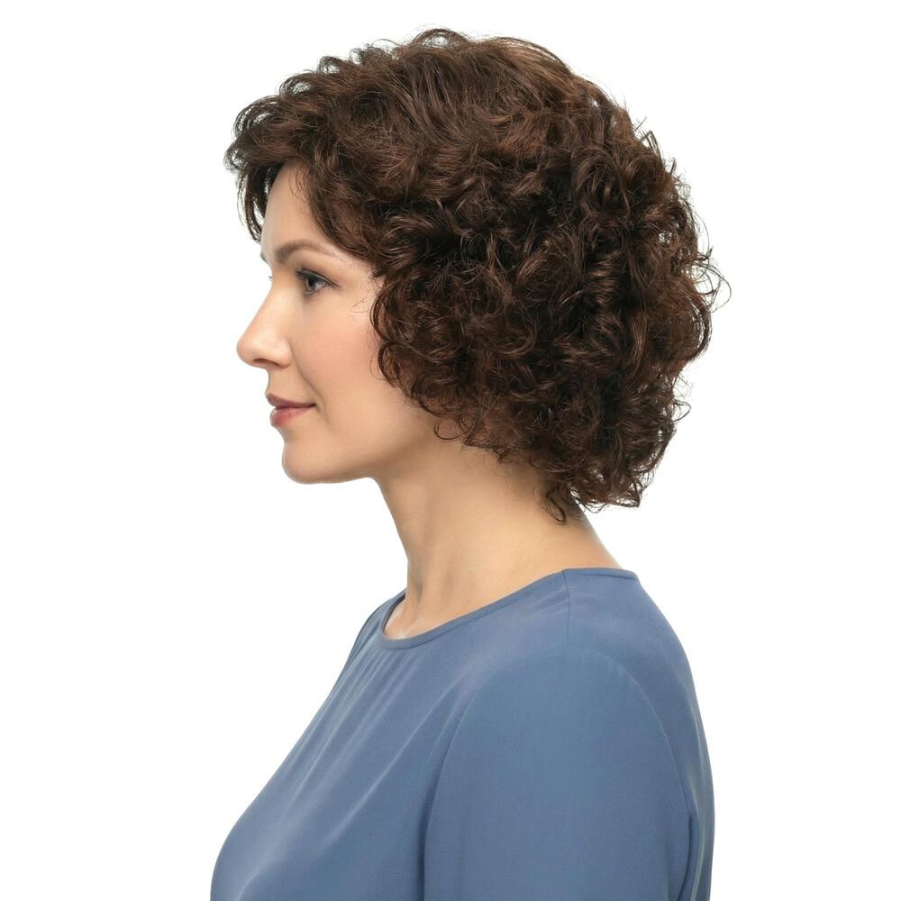 Frau mit brauner, lockiger Perücke. Seitenansicht. Blaues Oberteil. Weißer Hintergrund.