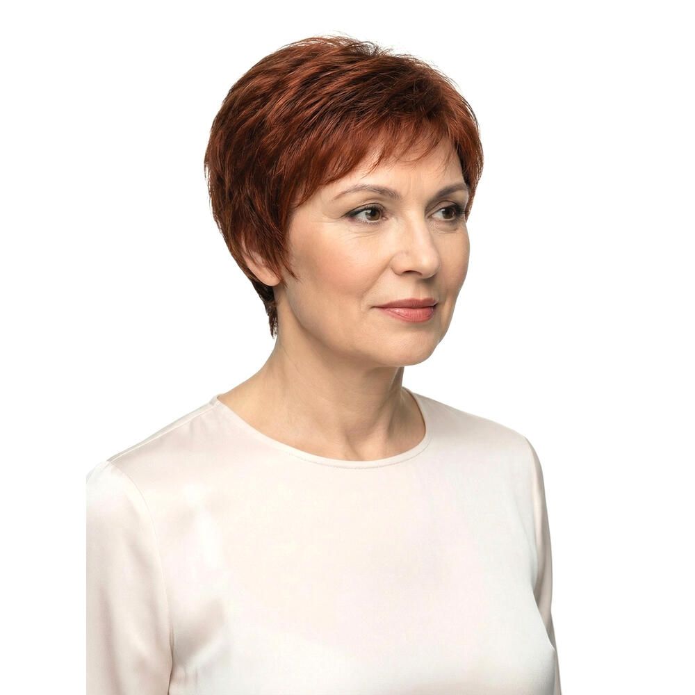 Frau mit rotbrauner Perücke. Kurzer, gestufter Schnitt. Dreiviertelansicht, Blick nach rechts. Helles Oberteil, weißer Hintergrund.
