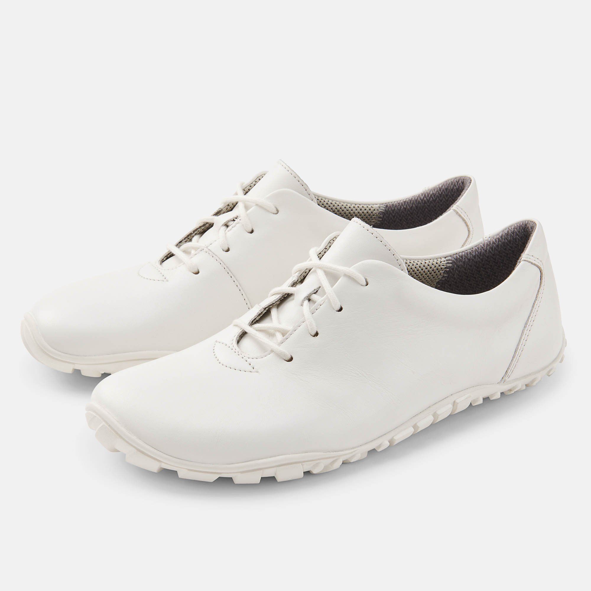Weiße Schnürschuhe. Lederoptik, breite Sohle. Zwei Schuhe nebeneinander, Schnürsenkel. Innenfutter grau.