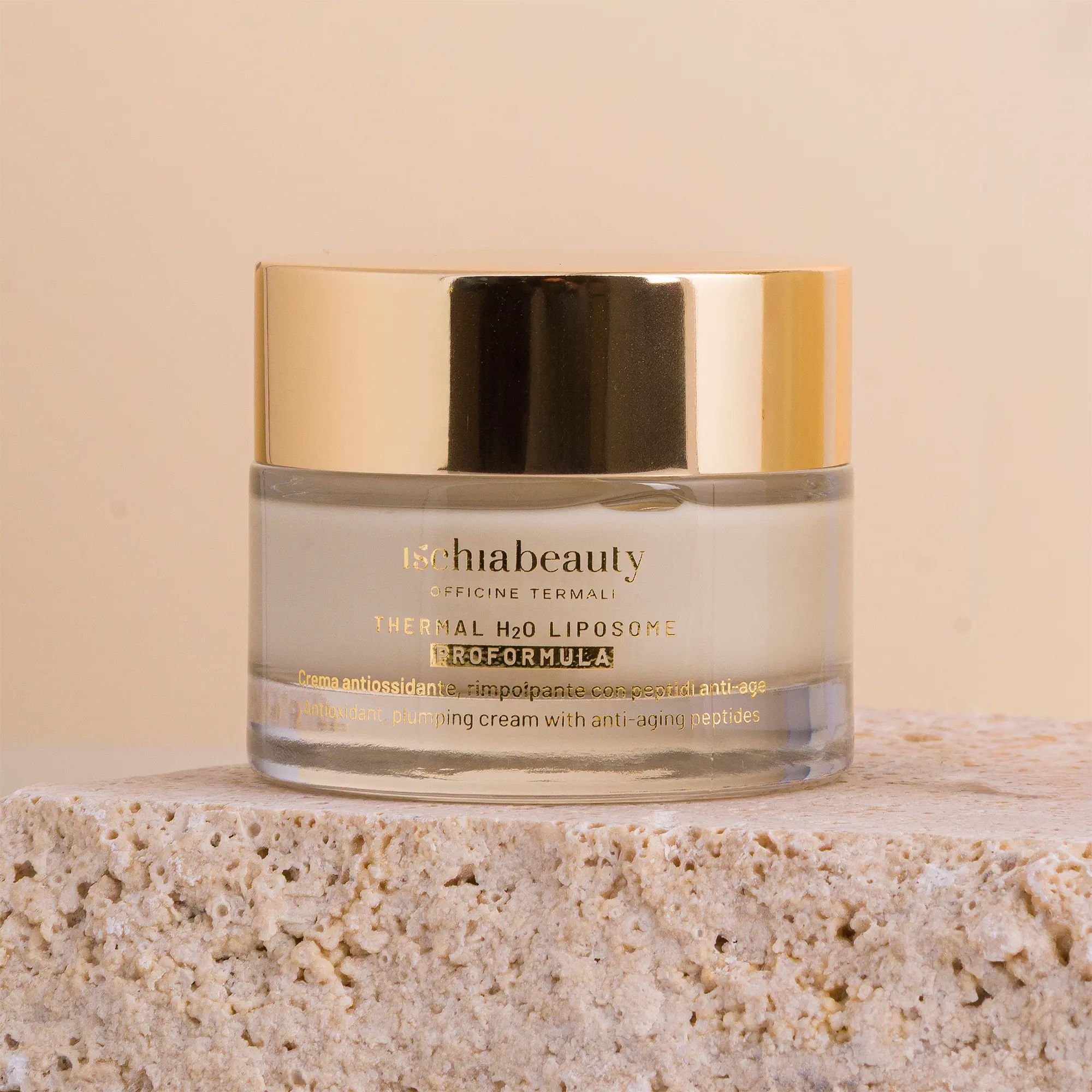 Cremebehälter mit goldenem Deckel. Auf Stein. Produktbeschriftung: Ischiabeauty, Thermal H2O Liposome Proformula.