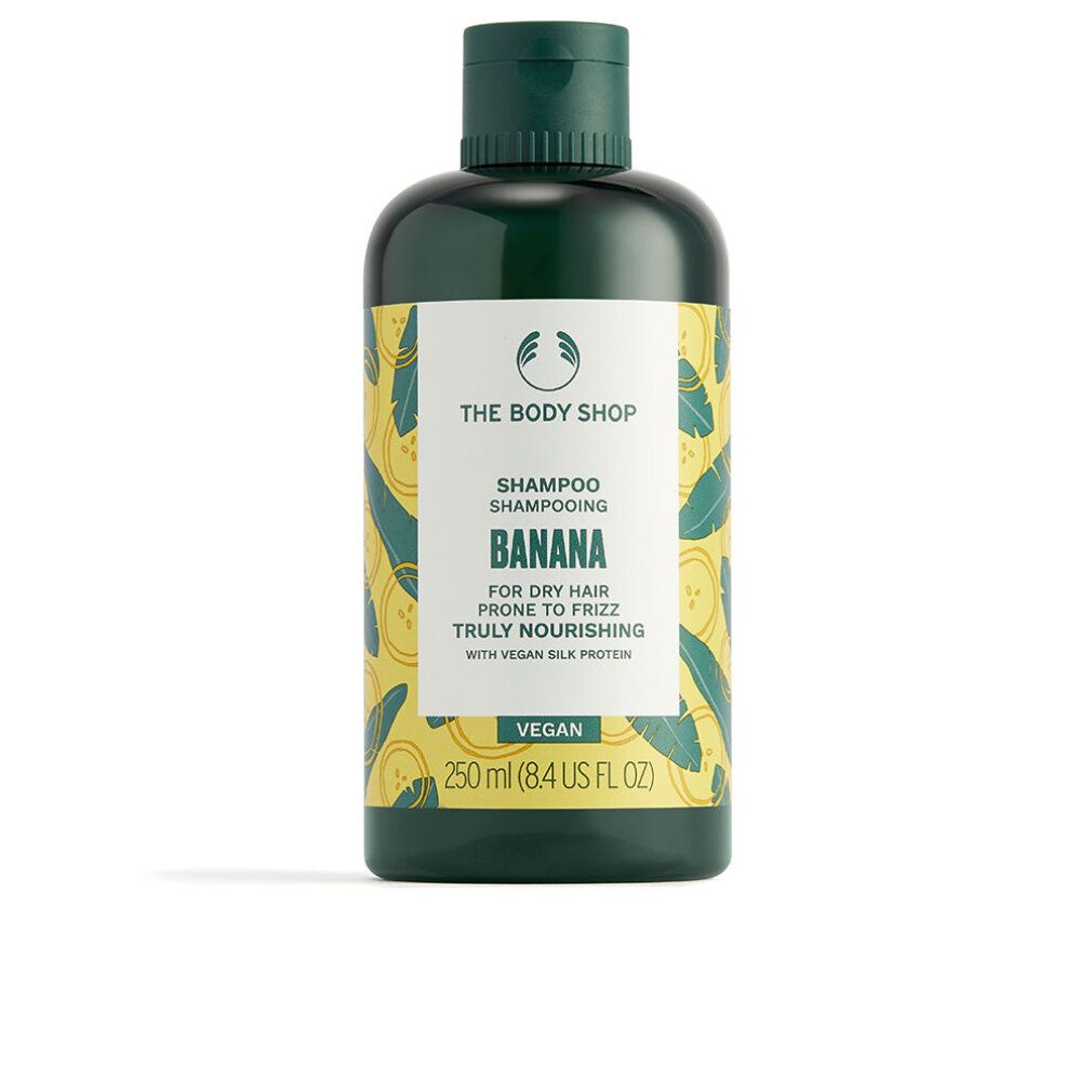Dunkelgrüne Shampoo-Flasche mit gelbem Etikett und Bananenmuster. Aufschrift: The Body Shop Banana Shampoo, 250 ml.